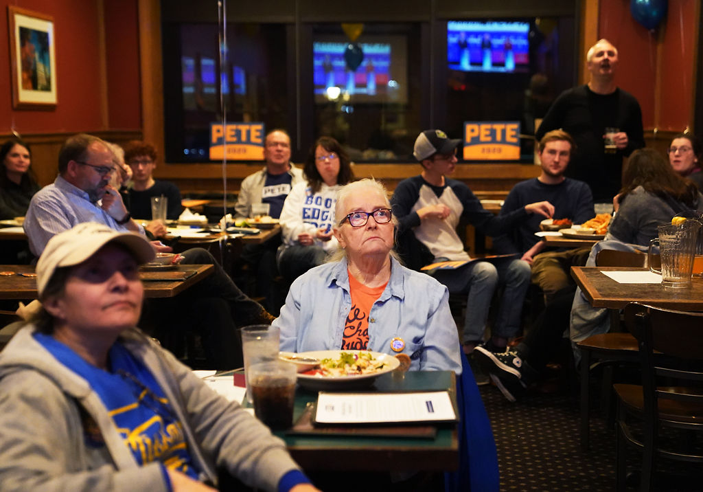 Barb Clark, center, watches the debate with other supporters of Pete Buttigieg